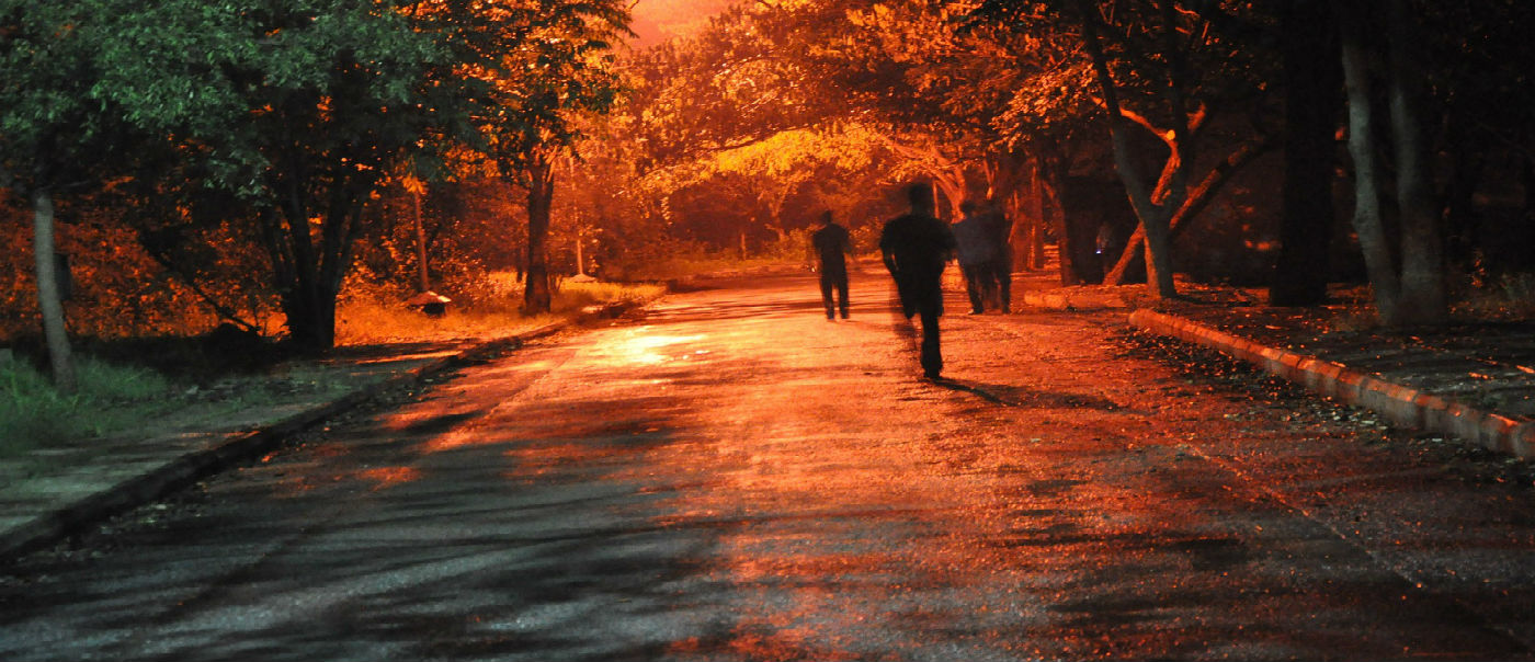 People standing on dark street.