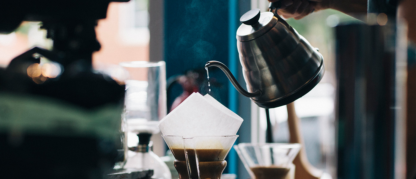 Carafe pouring coffee through filter