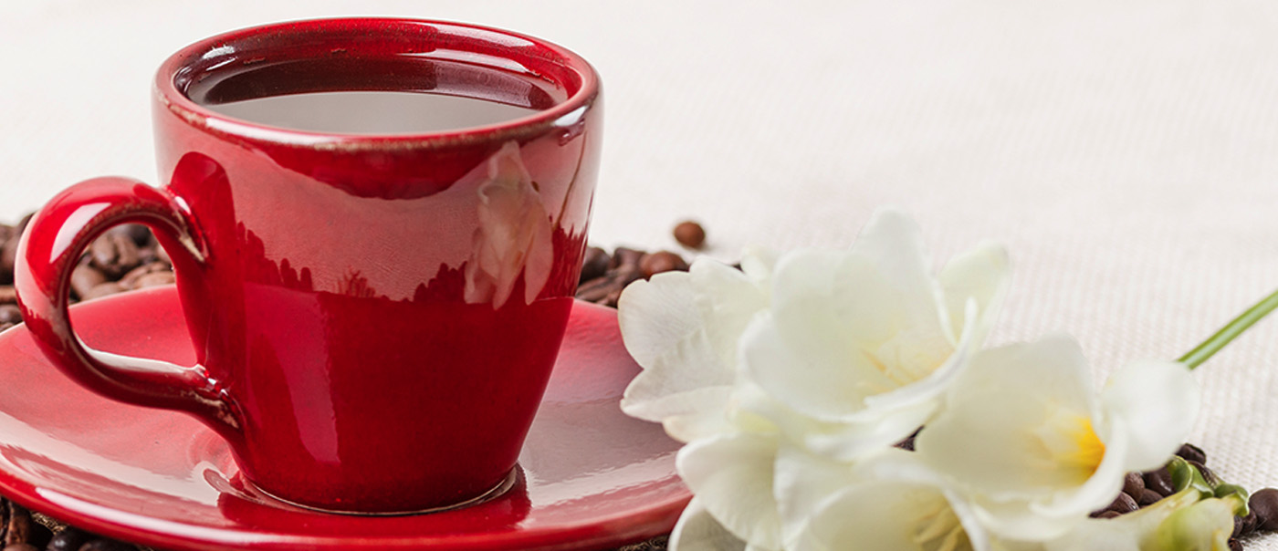 Red cup of coffee with flowers.