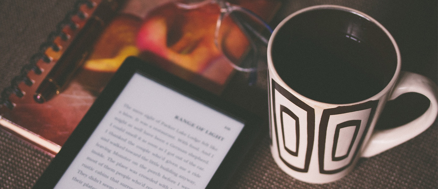 Coffee and tablet on a table.