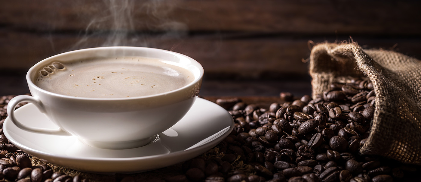 Hot coffee atop of some coffee beans.