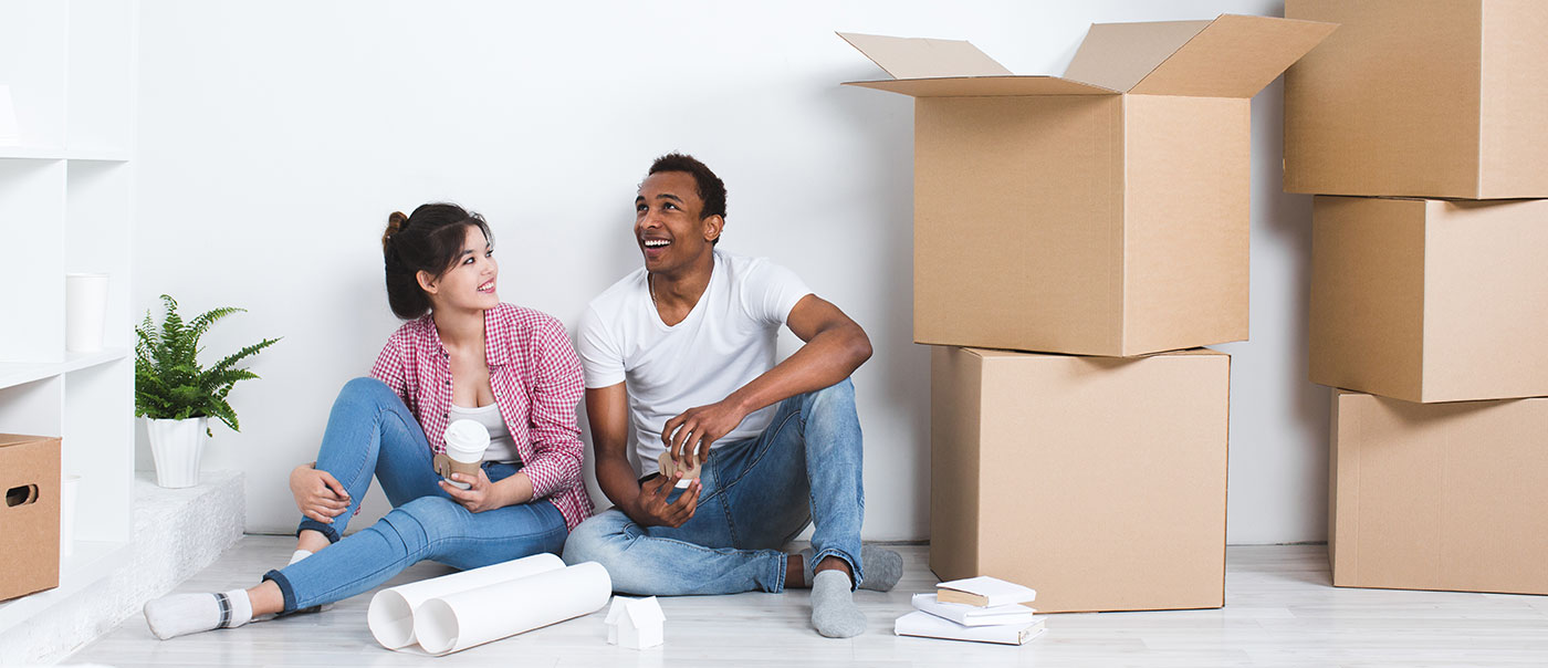 Couple sit in their new home.