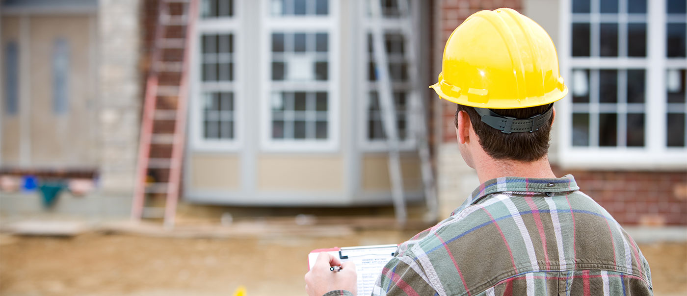 Man looking at home under construction.