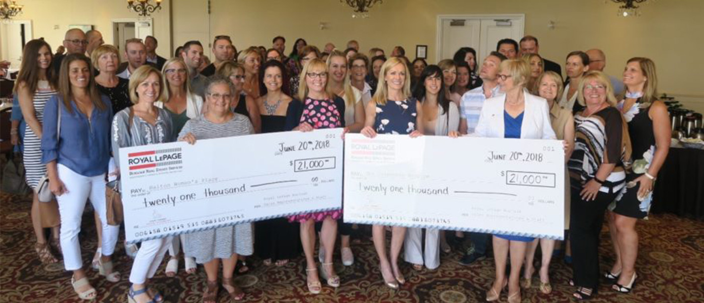 REALTORS holding a cheque.