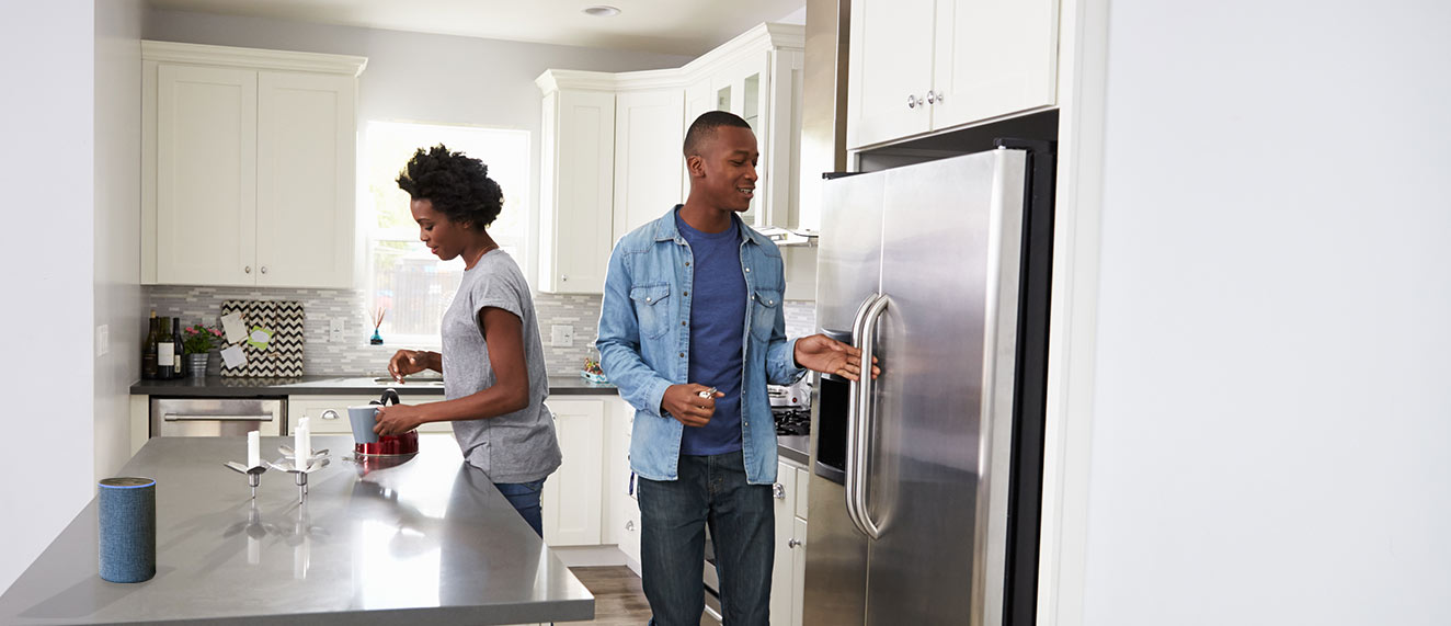 Couple using Alexa device in kitchen