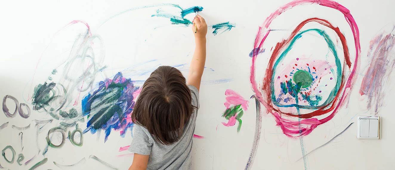 A child draws on the wall