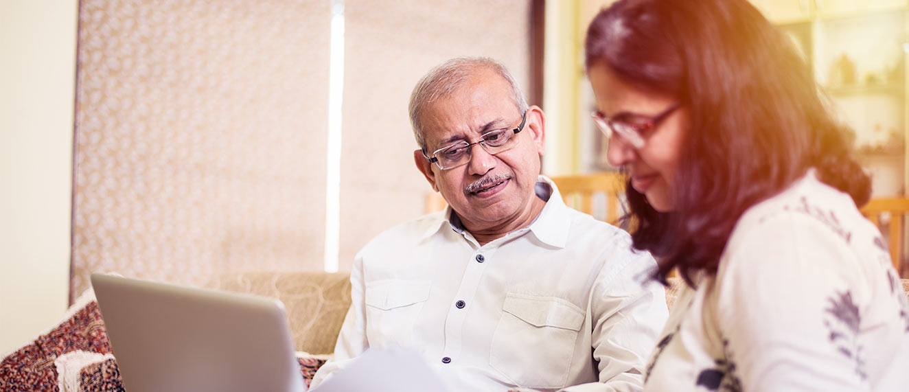 A couple looks at a computer screen.