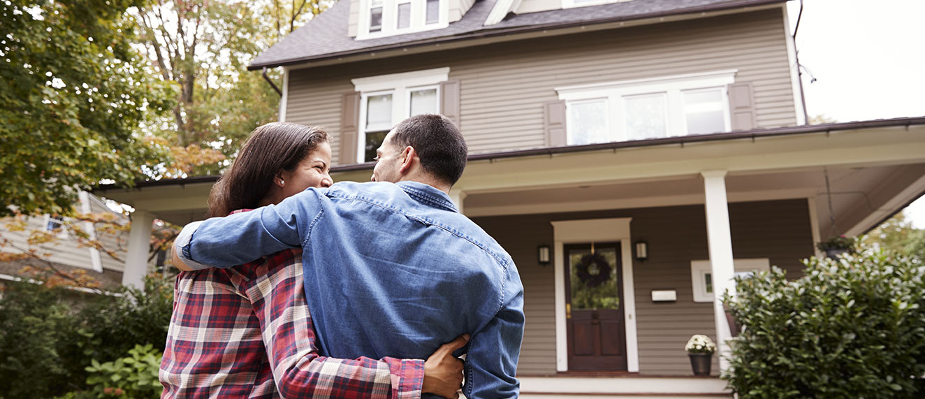 Couple standing in front of house.