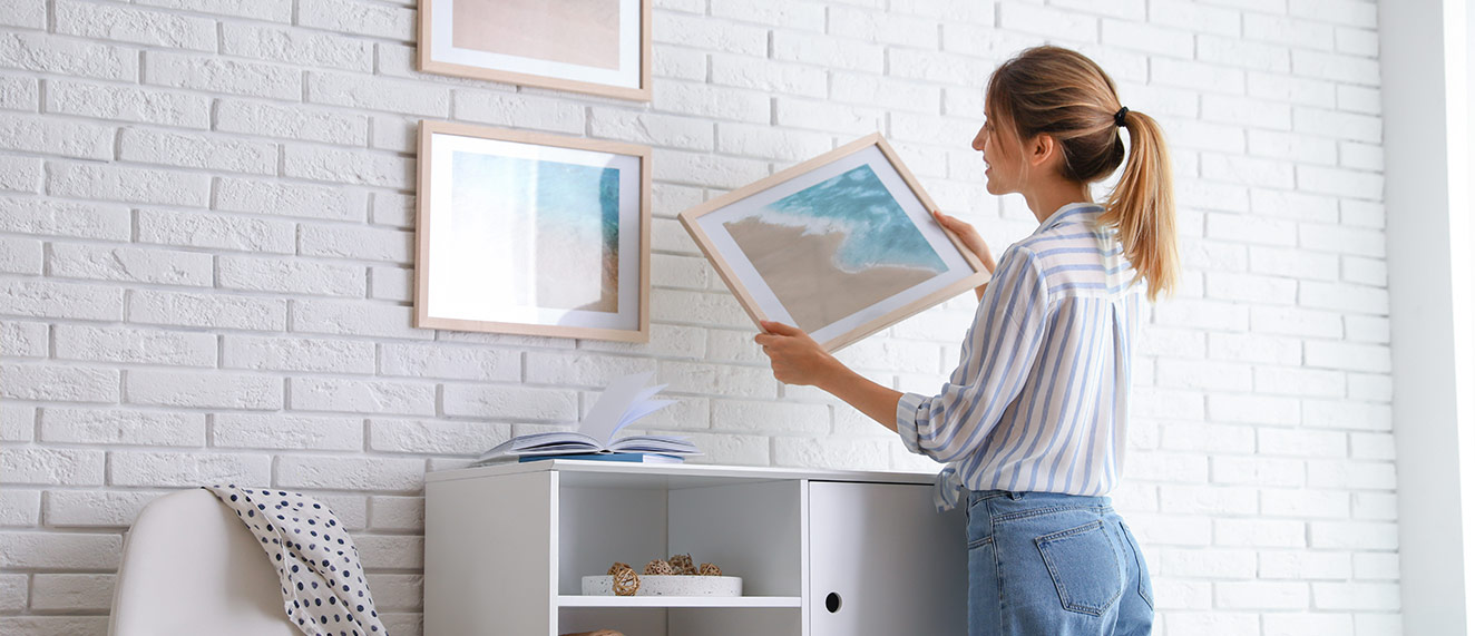 woman hanging gallery wall