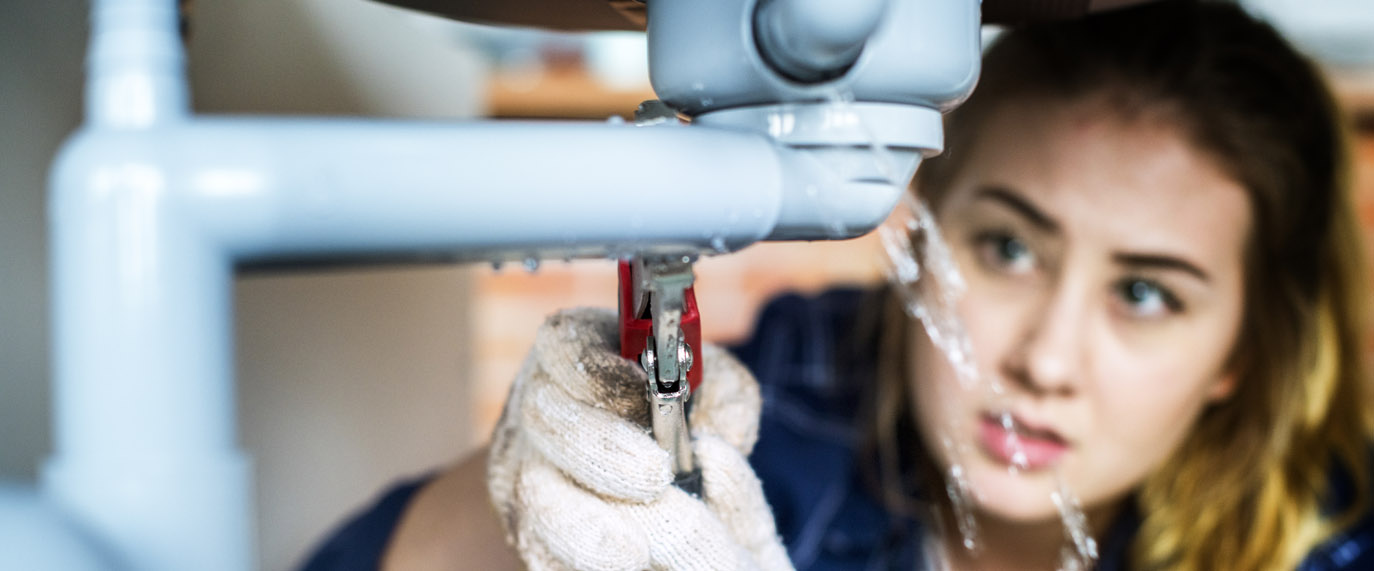 Woman repairing kitchen sink