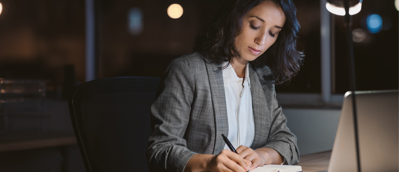 Woman sitting at desk doing paperwork.