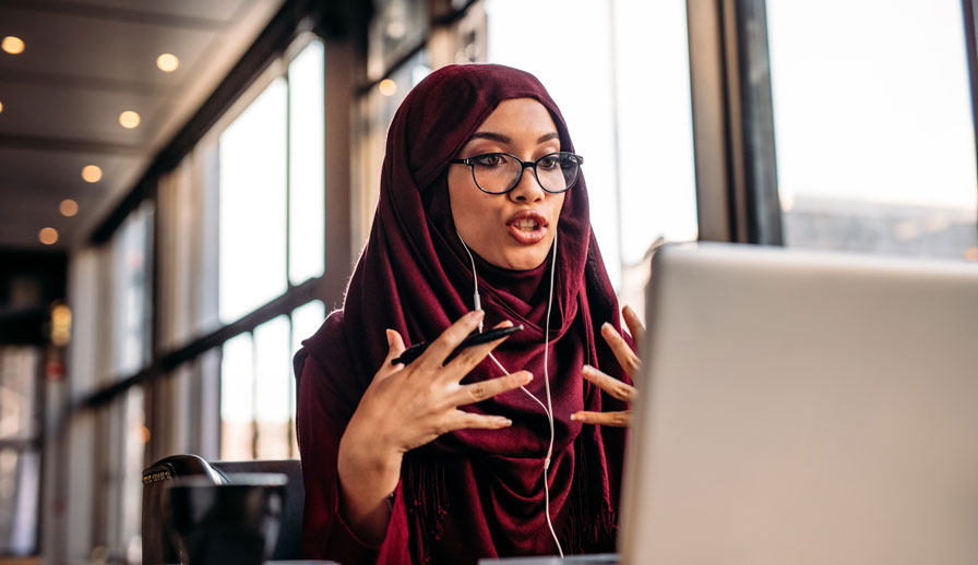 Young woman taking video call on laptop.