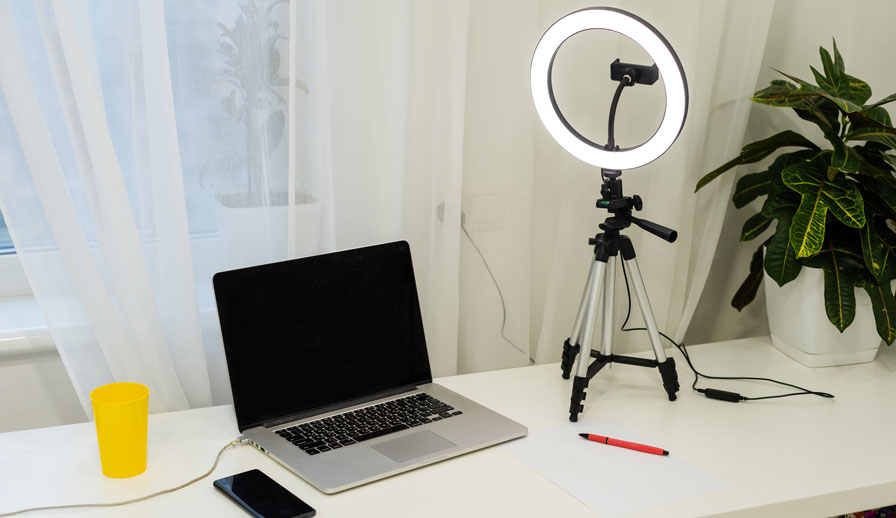 Laptop and ring light on desk.