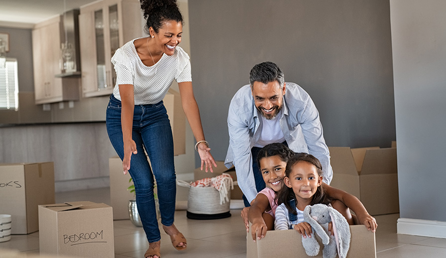 Parents playing with children while moving into new home.