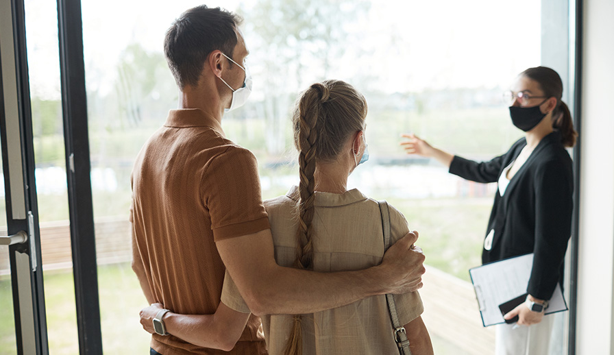 Real estate agent showing home to young couple.