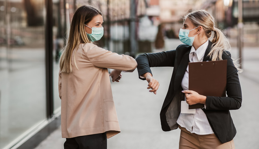 Two business women greeting each other