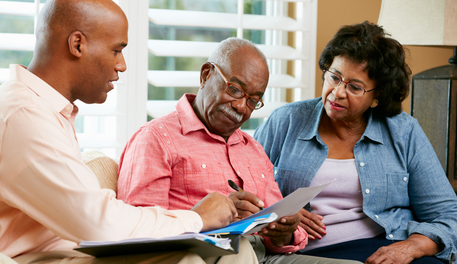 REALTOR showing papers to senior couple