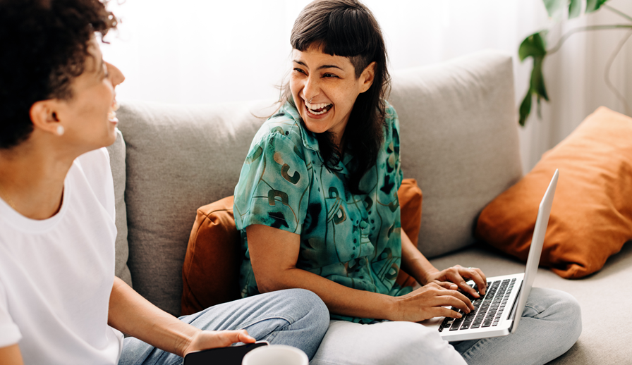 Young couple laugh on their couch