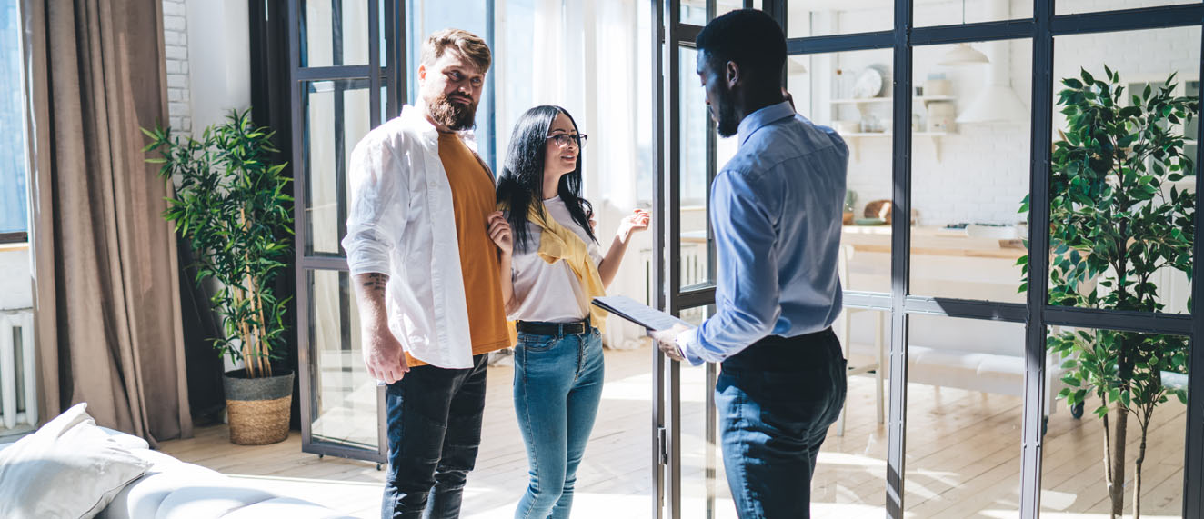 An agent interacting with a couple at an open house.