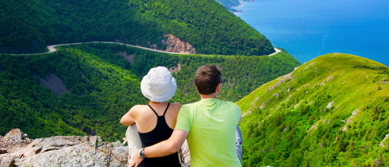 Couple sitting on trail in Cape Breton, Nova Scotia.