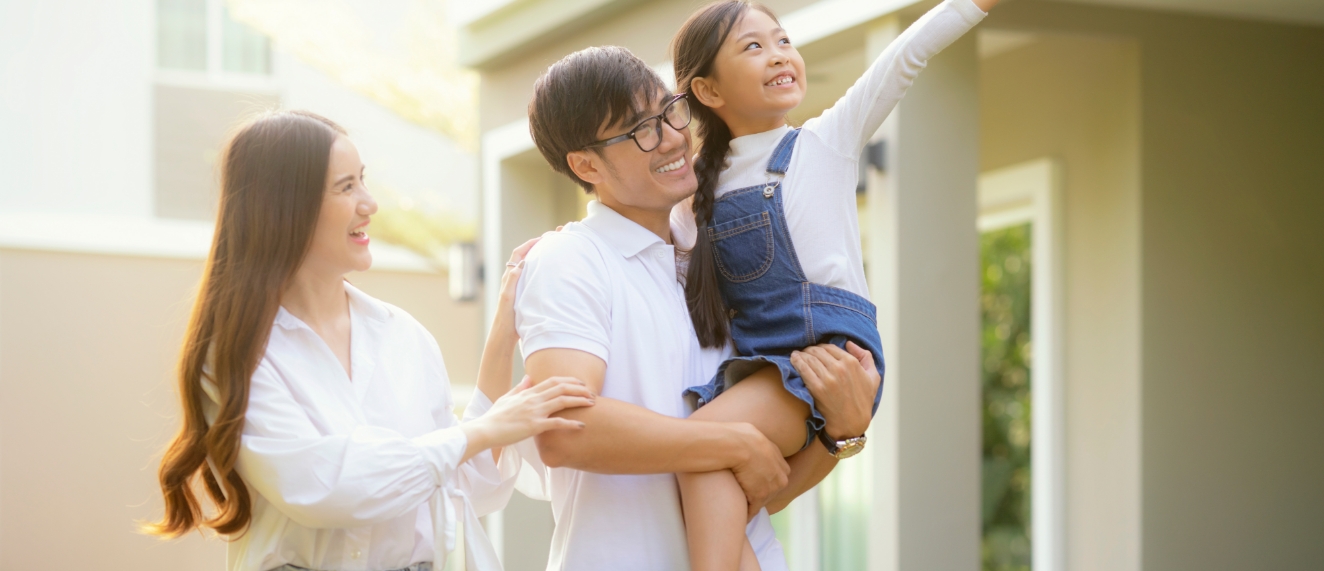 Happy family in front of house.