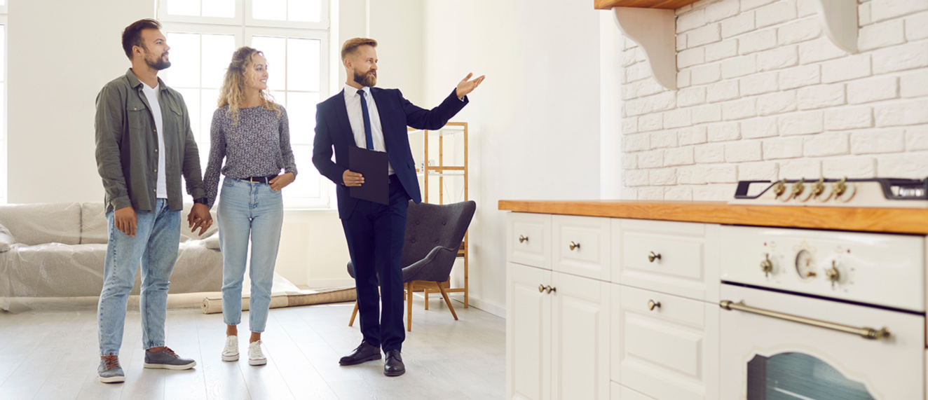 Real estate agent working with couple in bright house.