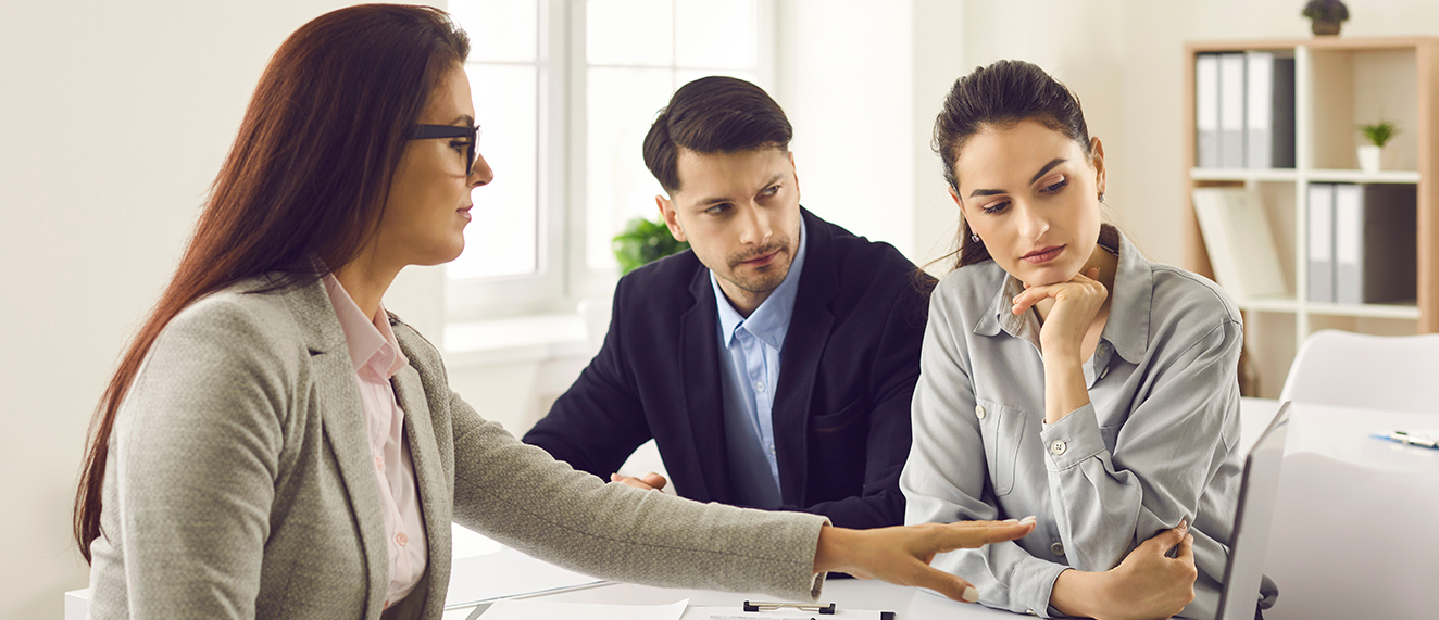 Couple speaking with female REALTOR(R).