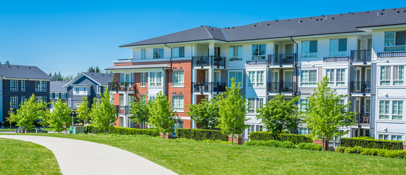 Apartment complex with lawn in foreground.