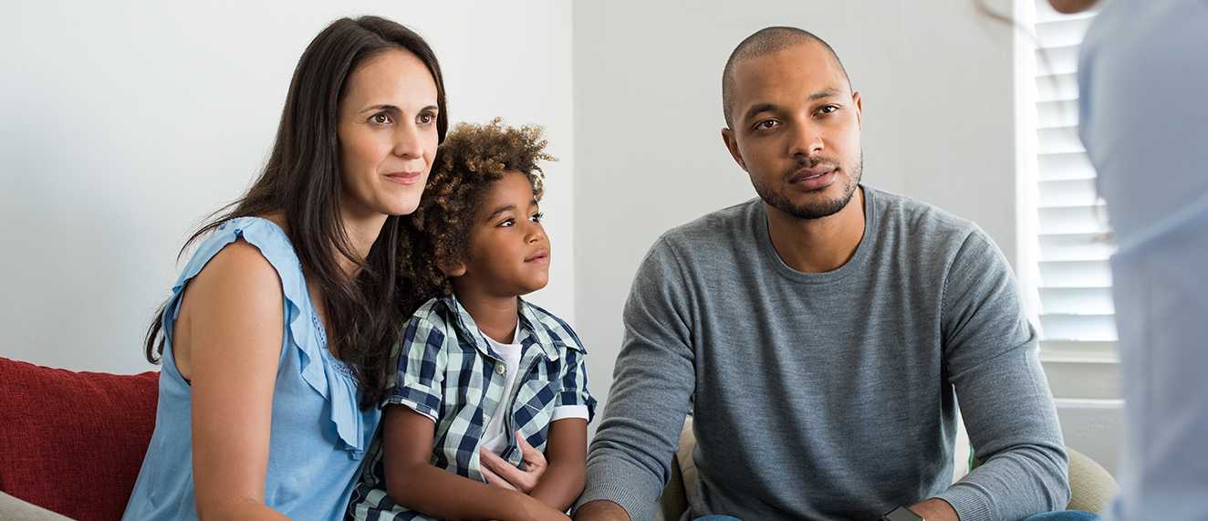 Couple with child on couch.