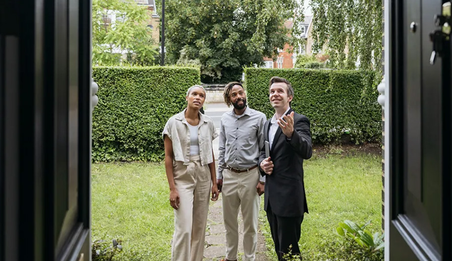 Three people looking at door. 