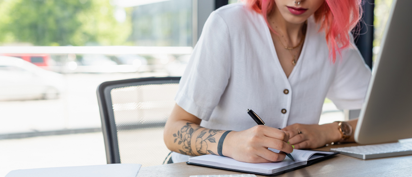 Young woman writing on notepad.