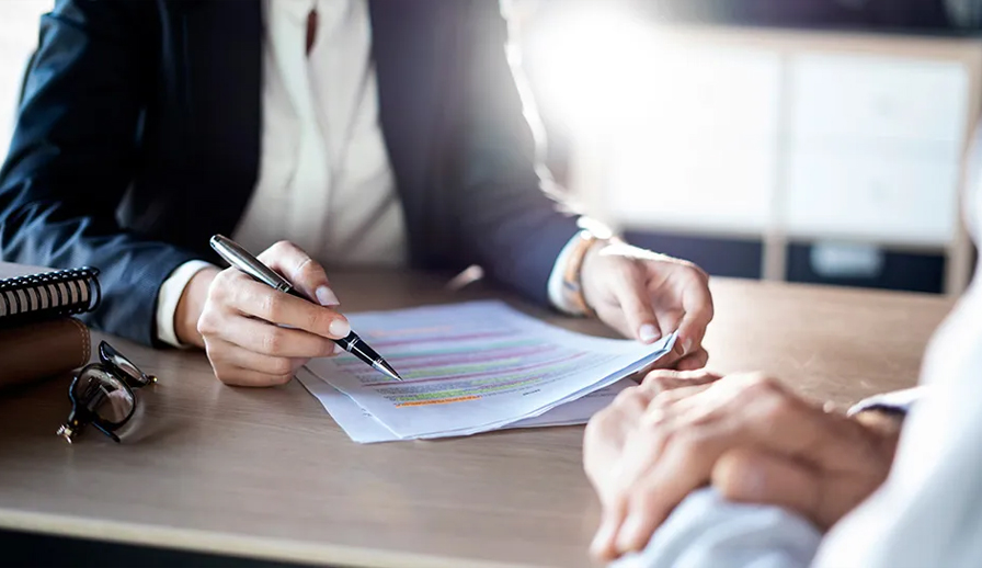 Business people sitting at table with papers.