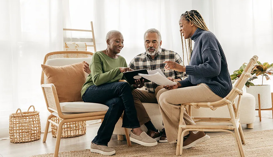 Elderly couple speaking with a real estate agent.