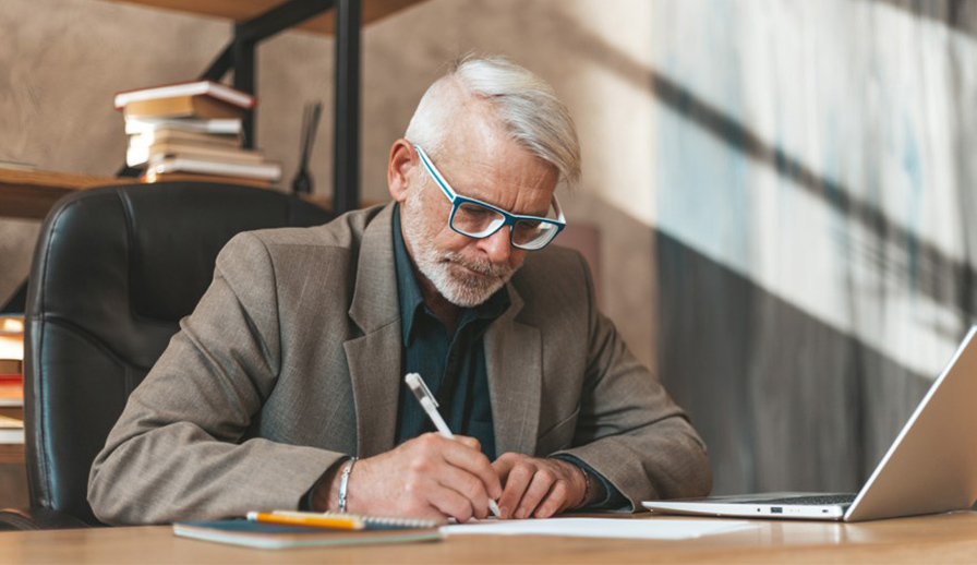 Man writing on piece of paper. 