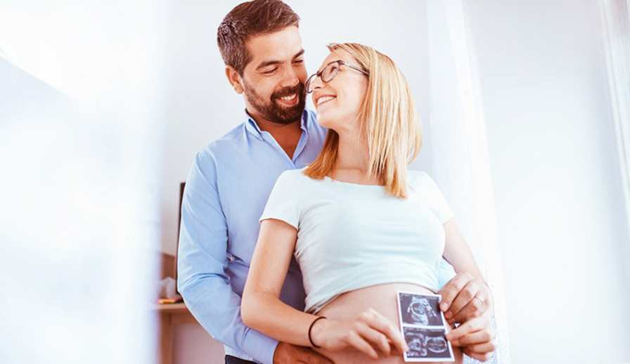 Pregnant couple with ultrasound photo.