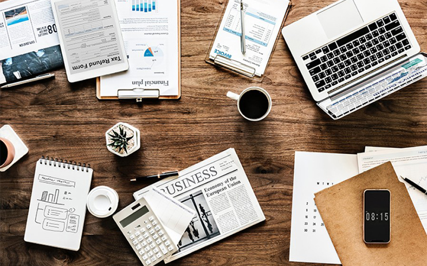 Newspaper on desk with coffee. 