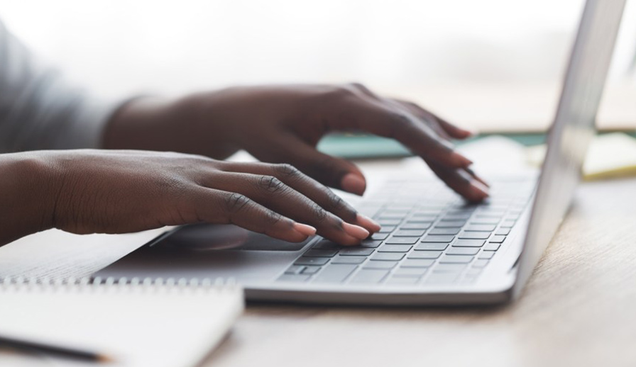 Person typing on a laptop. 