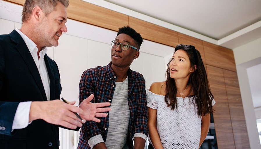 Couple speaking with real estate agent