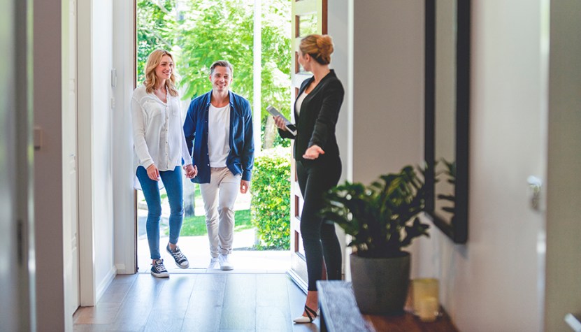 Couple entering a home showing. 