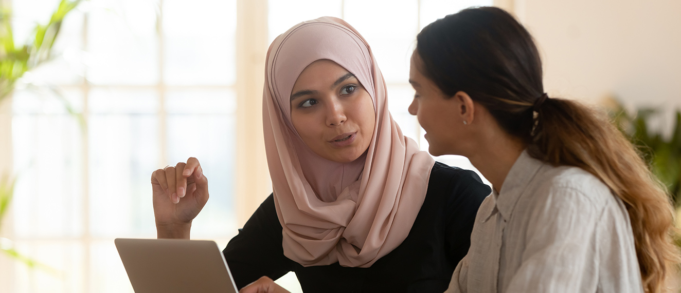 Women speaking over a laptop.