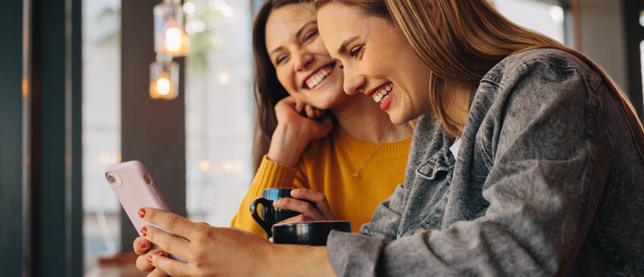 Two women looking at a phone together.