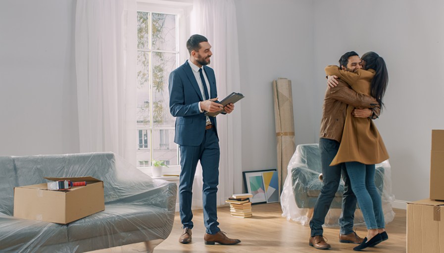 REALTOR(R) with clients in house hugging.