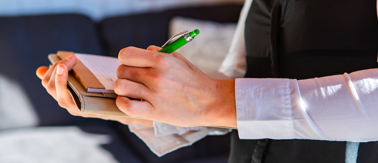 Person writing on a clipboard.